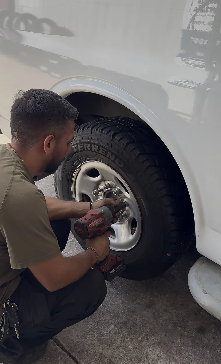 Mechanic tightening lug nuts on a new tire